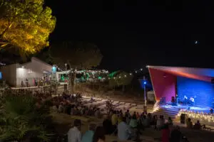 Auditorio del Parque El Camaleón de Islantilla en Huelva durante un concierto nocturno al aire libre.