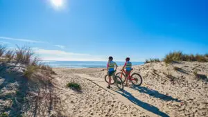Ciclistas recorriendo la costa de Islantilla con vistas al mar.