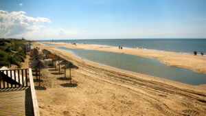 Playa de Islantilla en Huelva con arena dorada, sombrillas y mar tranquilo en la Costa de la Luz